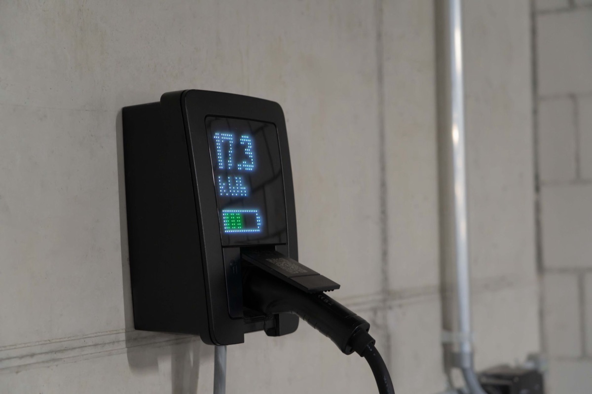 Une borne de recharge domestique fixée sur un mur de garage.
