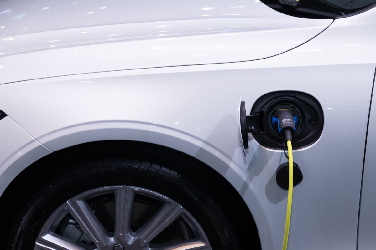 A sleek, minimalist electric vehicle charging station in a modern setting.