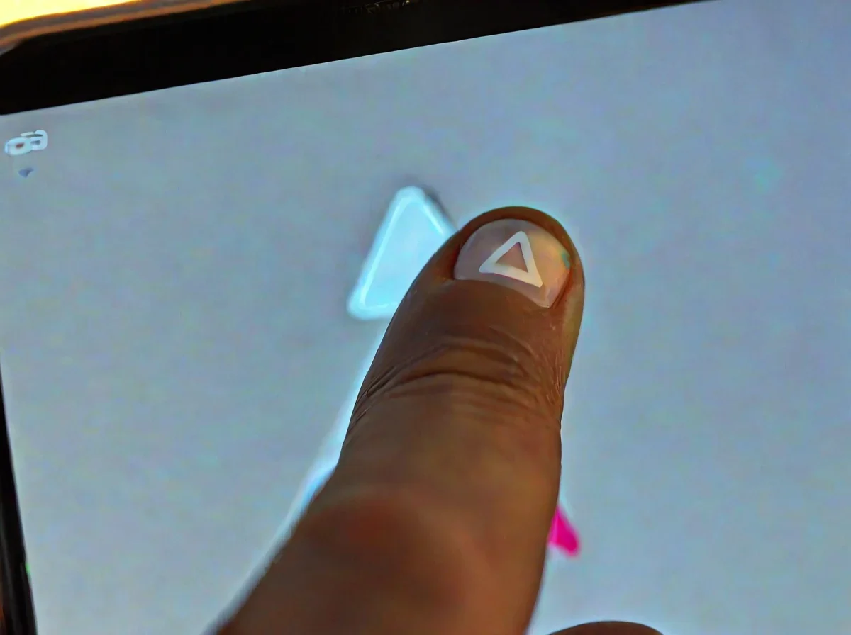 Foco em um dedo tocando o ícone de triangulo jogar branco em um smartphone brilhante.