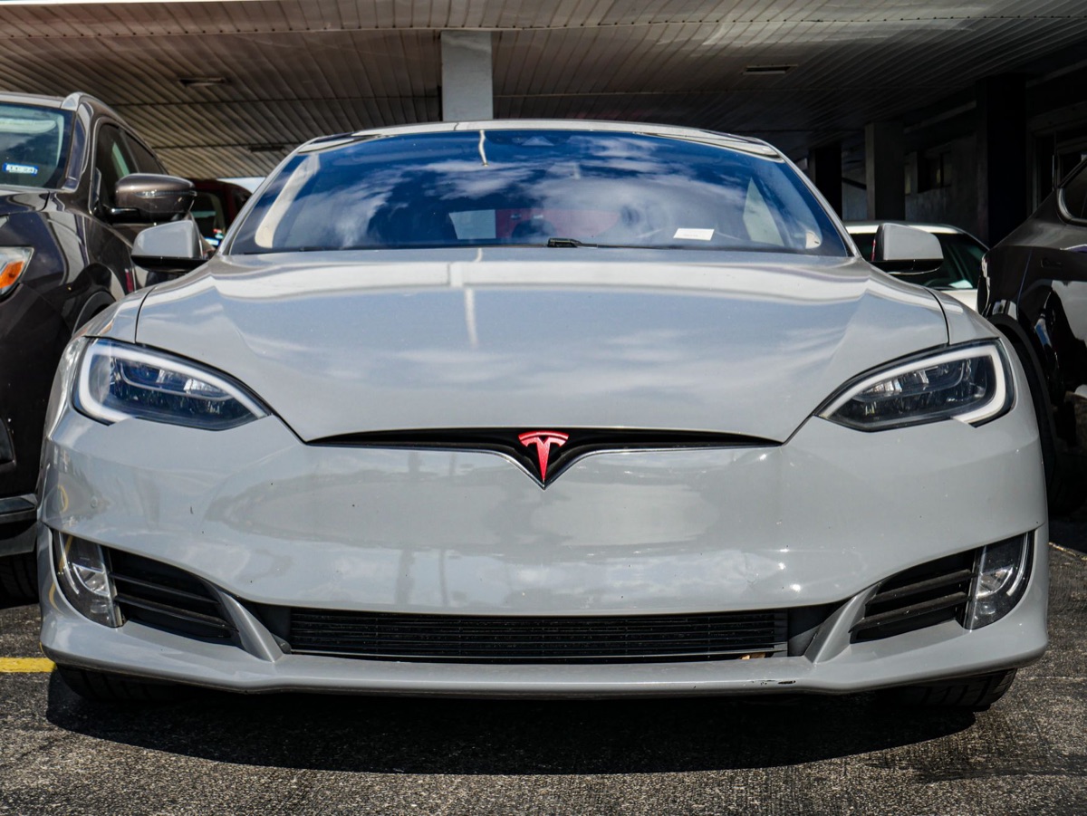 A modern Tesla Model S driving on a highway